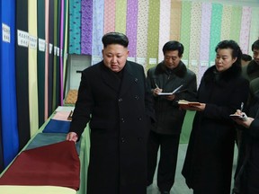 North Korean leader Kim Jong Un (L) gives field guidance at the Kim Jong Suk Pyongyang Textile Mill in this undated photo released by North Korea's Korean Central News Agency (KCNA) in Pyongyang December 20, 2014.  REUTERS/KCNA