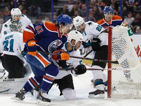 San Jose defenceman Dan Boyle (22) jumps into the net as Edmonton forward Anton Lander (51) rushes in during the first period of an NHL game between the San Jose Sharks and the Edmonton Oilers at Rexall Place in Edmonton, Alta., on Tuesday, March 25, 2014. Ian Kucerak/Edmonton Sun/QMI Agency