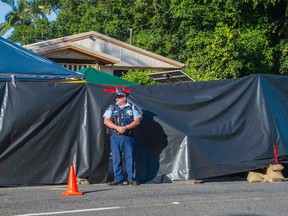 A policeman guards the scene of a stabbing attack at a home in Cairns, northern Queensland, December 19, 2014. Eight children have been killed and a woman who was mother to seven of them was injured in the northern Australian city of Cairns, police said on Friday, in what several media outlets reported was a mass stabbing. REUTERS/Stringer
