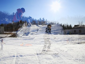 Skiers and snowboarders at Batawa Ski Hill in Quinte West, Ont. — seen here in a double exposure photograph — swing into the holidays as they enjoy the winter solstice on Sunday, Dec. 21, 2014. - JEROME LESSARD/THE INTELLIGENCER/QMI AGENCY