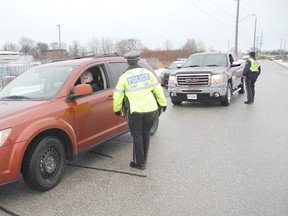 Orillia OPP Const. Bridget Laurin speaks to a driver during a RIDE check. (Andrew Phillips/Postmedia Network)