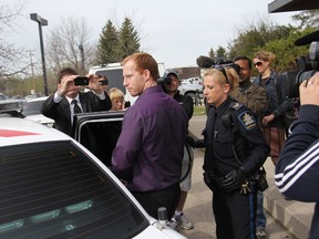 Accused killer Travis Vader is escorted out of court by police following his first court appearance in Edson on May 15 after he was charged with two counts of first degree murder in the deaths of a missing St. Albert couple. His next court appearance is scheduled for June 5.