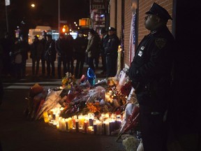 Police stand solemn vigil late at night at a makeshift memorial at the site where two police officers were shot in the head in the Brooklyn borough of New York, December 21, 2014.       REUTERS/Carlo Allegri