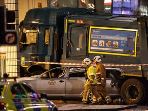 Rescue services personnel walk past a garbage truck that crashed into pedestrians in George Square, Glasgow, in Scotland December 22, 2014.   REUTERS/Stringer