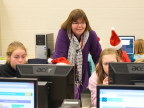Stoney Creek public school teacher Danielle Cadieux helps Grade 3 and 8 pupils as they take part in the Hour of Code in their school computer lab in London. (CRAIG GLOVER, The London Free Press)