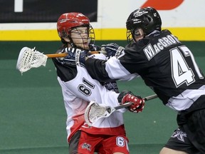 Calgary Roughnecks Matthew Hinsdale catches a stick to the throat from the Edmonton Rush’s Matt MacGrotty in preseason action at the Saddledome on Saturday. The Rush won 11-3. (Mike Drew, QMI Agency)