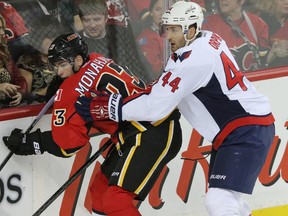 Calgary Flames forward Sean Monahan is taken into the boards by  Washington Capitals defenceman Brooks Orpik at the Saddledome in Calgary on October 25, 2014. (Mike Drew/Calgary Sun/QMI Agency)
