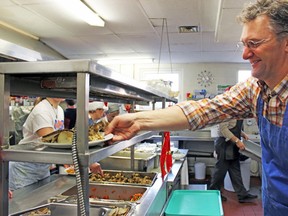 Paul Grogan picks up Christmas meals at Martha's Table Monday. The meal fed more than 250 patrons and  included turkey, stuffing, vegetables and dessert. Grogan and his 16-year-old daughter, Sophie, have been serving meals for the past two years.
