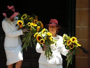 Members of an all-woman funeral company bring sunflowers out of St Stephens Uniting Church in Sydney, December 23, 2014. (REUTERS/Jason Reed)