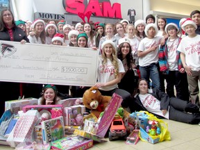 Saint Paul Catholic School students from Trenton present Maj. Tina Manuel of the Salvation Army with a donation of $1,500 along with toy donations following the students' flash mob at the Quinte Mall Saturday, Dec. 20. 
Submitted photo.