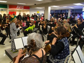 Noah McIlraith, 8 was one of the many children and others who took up the baton to lead London's orchestra musicians through some Christmas carols at London airport in London, Ont. on Monday December 22, 2014. 
(Mike Hensen/The London Free Press/QMI Agency)