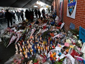 New York City Police officers visit a makeshift memorial at the site where two police officers were fatally shot in the Brooklyn borough of New York, December 23, 2014. REUTERS/Mike Segar