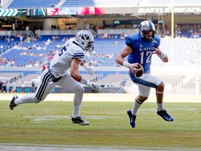 Paxton Lynch #12 of the Memphis Tigers rushes for a touchdown past defender Alani Fua #5 of the Brigham Young Cougar during the first quarter of the game against the Brigham Young Cougars at Marlins Park on December 22, 2014 in Miami, Florida.  Rob Foldy/Getty Images/AFP