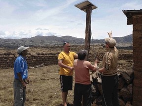 Dale Druer and Trisha Stecyk are local residents who went to Peru to install solar panels with nonprofit Light Up The World. Here, Dale (yellow shirt) installs one of the panels.