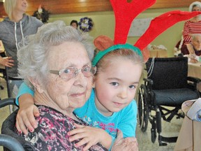 Zoey Michel (right) gives Evelyn Scott a hug during the 3rd annual 'Adopt a Grandparent' program at the Mitchell Nursing Home on Sunday, Dec. 21. The program helps the elderly “cheer up” over the holidays as each are given a gift, not to mention the personal contact with the youngsters. KRISTINE JEAN/MITCHELL ADVOCATE