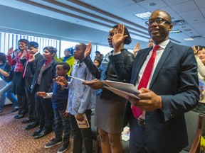 Stanley Chikombero (right), his wife, Diana Dinala, and their two children — Frank, 13, and Jacob, 7 — became Canadian citizens on Tuesday. (ERNEST DOROSZUK, Toronto Sun)