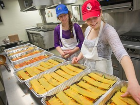 Algonquin College students Alex Donaldson and Laura Lebeau prepare trays of lasagna for Operation Big Turkey. Christmas eve dinners will be sent out to several community centres as part of the charitable event by Algonquin.​ DANI-ELLE DUBE/POSTMEDIA