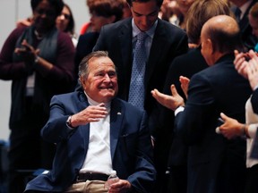Former United States President George H. W. Bush is brought into the auditorium where his son Former United States President George W. Bush speaks about his new book titled "41: A Portrait of My Father" at the George Bush Presidential Library Center in College Station, Texas November 11, 2014.  (REUTERS/Bob Daemmrich/Pool)