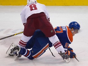 The Edmonton Oilers' David Perron (57) is hit by the Arizona Coyotes' Tobias Rieder (8) during second period NHL action at Rexall Place, in Edmonton Alta., on Tuesday Dec. 23, 2014. David Bloom/Edmonton Sun/QMI Agency