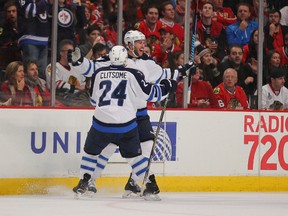 Dec 23, 2014; Chicago, IL, USA; Winnipeg Jets right wing Anthony Peluso (14) is congratulated for scoring by defenseman Grant Clitsome (24) during the first period against the Chicago Blackhawks at the United Center. Mandatory Credit: Dennis Wierzbicki-USA TODAY Sports