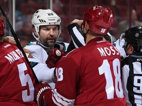 John Scott of the San Jose Sharks scrums with David Moss of the Arizona Coyotes during NHL preseason action  at Gila River Arena on October 3, 2014 in Glendale, Arizona. (Christian Petersen/Getty Images/AFP)