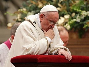 Pope Francis kneels as he leads the Christmas night mass in Saint Peter's Basilica at the Vatican December 24, 2014. (REUTERS/Max Rossi)