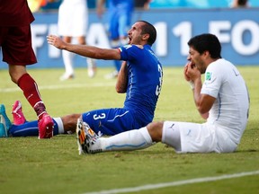 Uruguay's Luis Suarez (R) reacts after clashing with Italy's Giorgio Chiellini during their 2014 World Cup Group D soccer match at the Dunas arena in Natal June 24, 2014. (REUTERS/Tony Gentile)