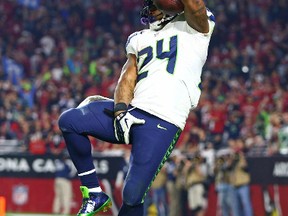 Seattle Seahawks running back Marshawn Lynch (24) grabs his crotch as he leaps into the end zone for a touchdown in the fourth quarter against the Arizona Cardinals at University of Phoenix Stadium on Dec 21, 2014 in Glendale, AZ, USA. (Mark J. Rebilas/USA TODAY Sports)