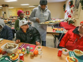 Volunteer Alrick, 42, and 11-year-old daughter Sidnone serve Christmas dinner at the Scott Mission on Spadina Ave. in Toronto Thursday December 25, 2014. (Dave Thomas/Toronto Sun)