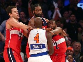 Washington Wizards point guard John Wall (2) hits New York Knicks small forward Quincy Acy (4) in front of Wizards power forward Kris Humphries (43) and Wizards power forward Nene Hilario (42) during the fourth quarter at Madison Square Garden on Dec 25, 2014 in New York, NY, USA. (Brad Penner/USA TODAY Sports)
