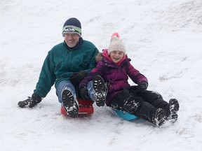Arne Peltz (l) and his seven-year-old grand daughter Aliyah Smith take advantage of the warm weather to do some sledding in Winnipeg, Thursday Dec. 25, 2014. (Brian Donogh/QMI Agency)