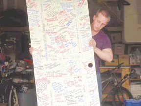 Josh Yandt holds a door signed by fellow Clarke Road secondary school students in an online video featured in a WestJet showcase of Canadians who go above and beyond to make a difference. (Special to The Free Press)