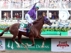 Victor Espinoza aboard California Chrome celebrates as they cross the finish line to win the 2014 Kentucky Derby at Churchill Downs in Louisville, Ky., on May 3, 2014. (JERRY LAI/USA TODAY Sports)