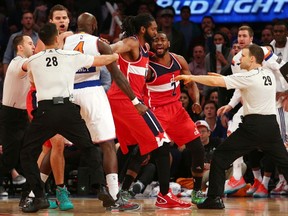 Washington Wizards point guard John Wall (2) is separated from New York Knicks small forward Quincy Acy (4) by Wizards power forward Nene Hilario (42) and officials Zach Zarba (28) and Mark Lindsay (29) during the fourth quarter at Madison Square Garden on Dec 25, 2014 in New York, NY, USA. (Brad Penner/USA TODAY Sports)