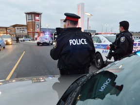 Police close the perimeter of Tanger Outlets Mall in Kanata where a shooting occurred on Friday, Dec. 26, 2014. Two men are in custody and cops are searching for two more suspects. 
Matthew Usherwood/Ottawa Sun