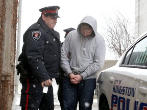 Mackenzie McDonald, 25, leaves court on Jan. 17, 2014, in custody with Kingston Police Const. Rick Poirier after being sentenced for aggravated assault from an incident in 2008. (Ian MacAlpine/The Whig-Standard)