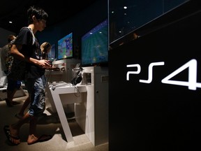 A man plays a video game on Sony Corp's PlayStation 4 console at its showroom in Tokyo in this July 16, 2014 file picture. REUTERS/Yuya Shino/Files