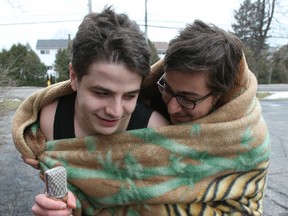 Anas Marwah, left, and Mohamed El Koussy bundle up after receiving an online donation of $10 as part of the Keep Us Warm Campaign to Keep a Refugee Warm Saturday, Dec. 27, 2014 held by the Syrian Association of Ottawa. The event raised funds via a YouTube live stream. Volunteers stood in the cold in shorts and tank tops for more than 2 hours.
DOUG HEMPSTEAD/Ottawa Sun/QMI AGENCY