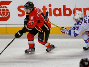 Calgary Flames Johnny Gaudreau carries the puck up ice against Martin St. Louis of the New York Rangers during NHL hockey in Calgary, Alta. on Tuesday December 16, 2014. Al Charest/Calgary Sun/QMI Agency