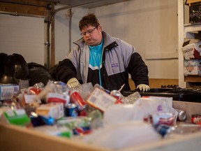 Eric Parent, one of the Community Lunch Box's paid bottle sorters, sorts donated bottles and cans on Tuesday December 16, 2014 in Whitecourt. The Community Lunch Box has hired four employees to help manage its ongoing bottle collection service, this service has become a self-sustaining business, paying for the employees it needs while also turning a profit to help fund the lunchbox program. Most of the people hired are adults with disabilities, lunchbox coordinator Tara Baker said she wanted there to be a safe place in town for adults with disabilities to be able to hold down jobs and be comfortable.