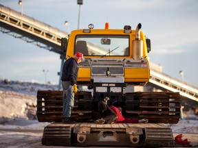 From left, Dave Newbury and Jim Hearn from the Whitecourt Trailblazers are pictured working to disconnect their newly arrived trail groomer from the chains holding it to the trailer that transported it from Calgary to Whitecourt, on Saturday December 20, 2014 in Whitecourt, Alta. The machine was originally used on ski hills in western Alberta and recently overhauled in Calgary. Total Oilfield Services donated the trucking time and resources to haul it to Whitecourt.