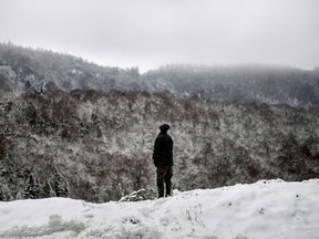 A man looks at the snowy landscape on Dec. 28, 2014 near Oyonnax, near the Swiss border west of Geneva.  (AFP PHOTO/JEFF PACHOUD)