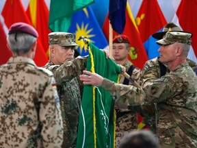 U.S. General John Campbell (C), commander of NATO-led International Security Assistance Force (ISAF), folds the flag of the ISAF during the change of mission ceremony in Kabul, Dec. 28, 2014.  REUTERS/Omar Sobhani