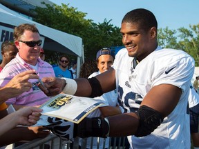 St. Louis Rams defensive lineman Michael Sam signs autographs after practice at Rams Park in this file photo taken in St Louis, Missouri, July 29, 2014. (REUTERS/Scott Rovak/USA TODAY Sports)