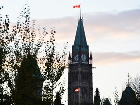 The sun sets behind Parliament Hill in Ottawa in this Oct. 22, 2014 file photo. (Matthew Usherwood/QMI Agency)