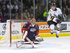 London Knights forward Aaron Berisha jumps to let the puck through while attempting to screen Windsor Spitfires goaltender Brendan Johnston, who saved the shot, during their Ontario Hockey League game at Budweiser Gardens on Sunday.  Windsor won the game 5-4 in a shootout. (CRAIG GLOVER, The London Free Press)
