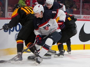 American Jack Eichel fights for the puck against German Marc Michaelis in the first period of a game during the 2015 IIHF World Junior Championship on December 28, 2014 at the Bell Centre (JOHANY JUTRAS/LE JOURNAL DE MONTRÉAL/QMI AGENCY.)