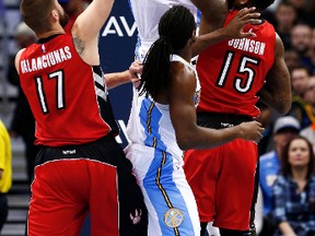 Nuggets forward Wilson Chandler goes up for a shot over Raptors centre Jonas Valanciunas (left) and Amir Johnson in Denver on Sunday night. (AFP)