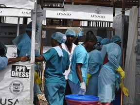 Health workers enter an Ebola treatment center in Monrovia, Liberia, December 16, 2014. REUTERS/James Giahyue