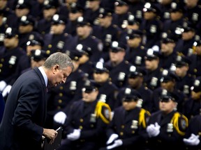 New York Mayor Bill de Blasio walks away from the podium after speaking to the New York City Police Academy Graduating class in New York December 29, 2014. Hundreds of officers took part in the ceremony at Madison Square Gardens. REUTERS/Carlo Allegri